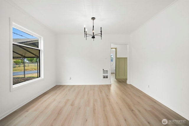 2104 Stuart St, Raymond, WA 98577 - spare room featuring plenty of natural light, a chandelier, light wood-style flooring, and ornamental molding