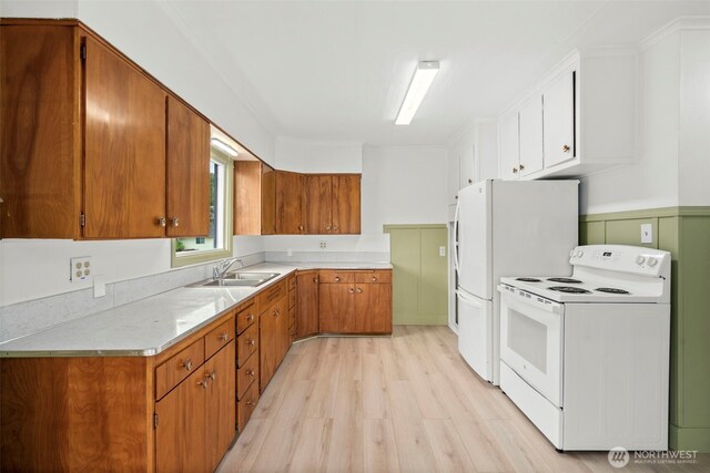 2104 Stuart St, Raymond, WA 98577 - kitchen featuring white appliances, light wood-style flooring, brown cabinets, and light countertops