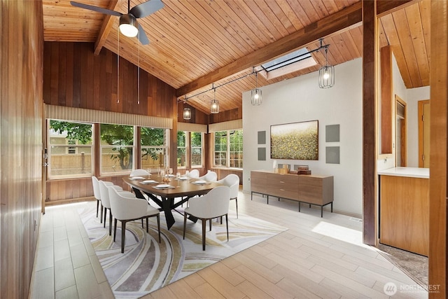 383 E Piper Way, Camano Island, WA 98282 - dining room featuring a wooden ceiling with exposed beams, a skylight, ceiling fan, light wood-style floors, and wood walls