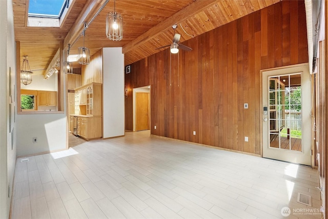 383 E Piper Way, Camano Island, WA 98282 - unfurnished living room with a skylight, wooden ceiling, wood walls, and light wood-style flooring