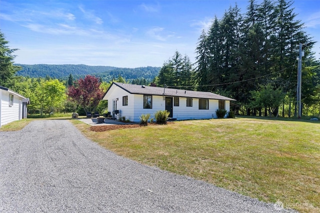 1173 Grauel Ramapo Rd, Port Angeles, WA 98363 - ranch-style home featuring driveway, a front lawn, and a view of trees