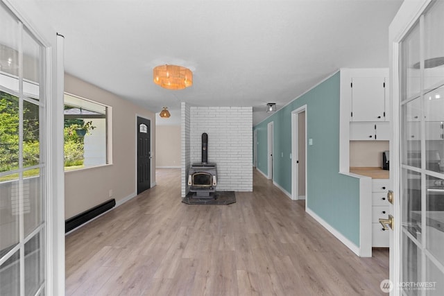 1173 Grauel Ramapo Rd, Port Angeles, WA 98363 - unfurnished living room featuring light wood finished floors, a wood stove, and baseboard heating