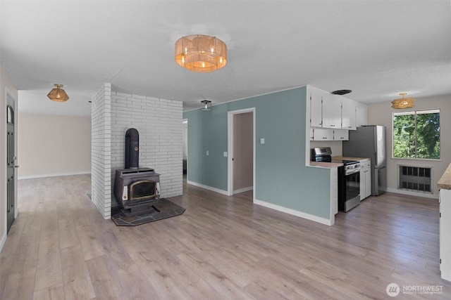 1173 Grauel Ramapo Rd, Port Angeles, WA 98363 - unfurnished living room featuring a wood stove and light wood-type flooring