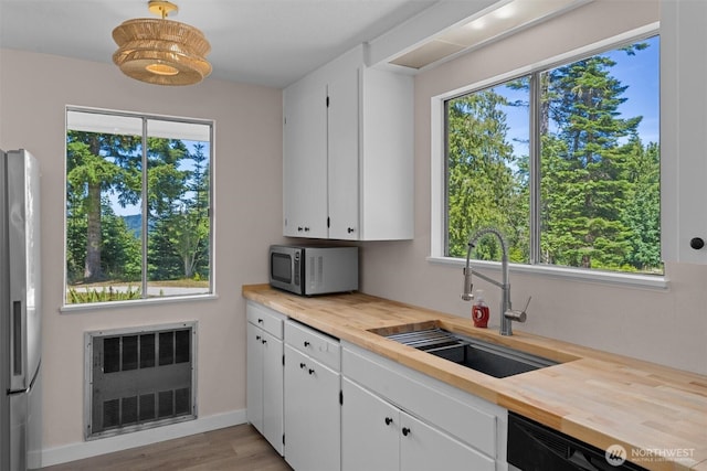 1173 Grauel Ramapo Rd, Port Angeles, WA 98363 - kitchen featuring stainless steel appliances, radiator heating unit, butcher block counters, and white cabinetry