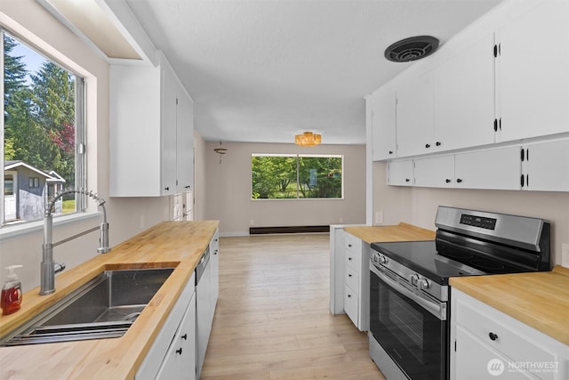 1173 Grauel Ramapo Rd, Port Angeles, WA 98363 - kitchen featuring appliances with stainless steel finishes, butcher block counters, light wood-style flooring, and white cabinets