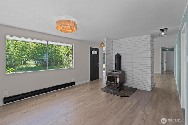 1173 Grauel Ramapo Rd, Port Angeles, WA 98363 - unfurnished living room featuring baseboard heating, wood finished floors, and a wood stove