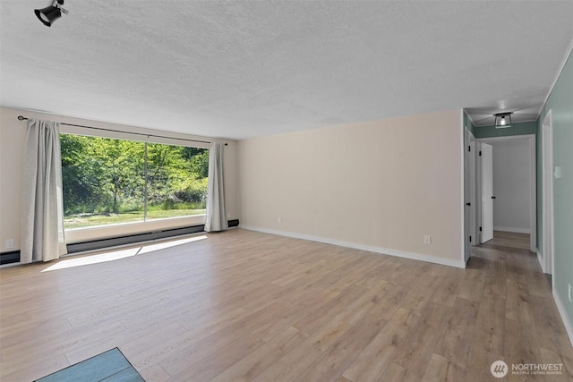 1173 Grauel Ramapo Rd, Port Angeles, WA 98363 - unfurnished living room featuring light wood-style floors and a textured ceiling