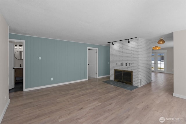 1173 Grauel Ramapo Rd, Port Angeles, WA 98363 - unfurnished living room featuring rail lighting, wood finished floors, and a fireplace