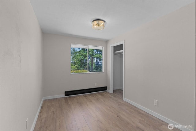 1173 Grauel Ramapo Rd, Port Angeles, WA 98363 - unfurnished bedroom with a baseboard heating unit, wood finished floors, and a closet