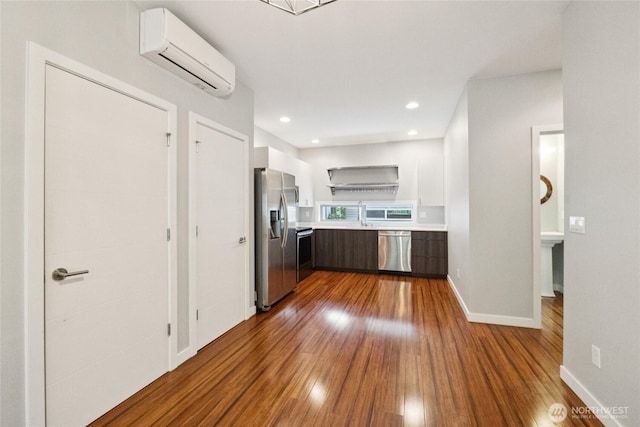 4214 S Trenton St, Seattle, WA 98118 - kitchen with stainless steel appliances, a wall mounted AC, light countertops, dark wood finished floors, and recessed lighting