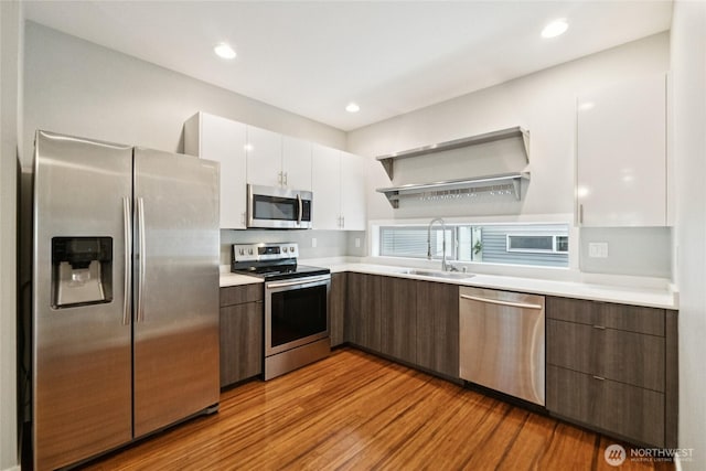 4214 S Trenton St, Seattle, WA 98118 - kitchen with stainless steel appliances, white cabinetry, light countertops, light wood-type flooring, and modern cabinets