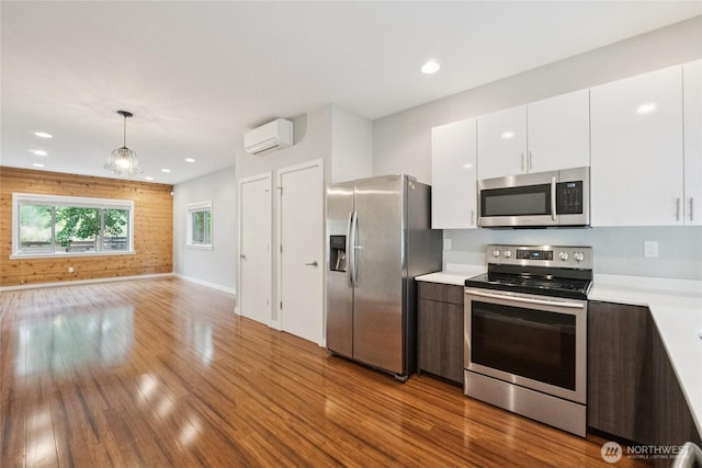 4214 S Trenton St, Seattle, WA 98118 - kitchen featuring appliances with stainless steel finishes, a wall mounted AC, wood finished floors, light countertops, and white cabinets