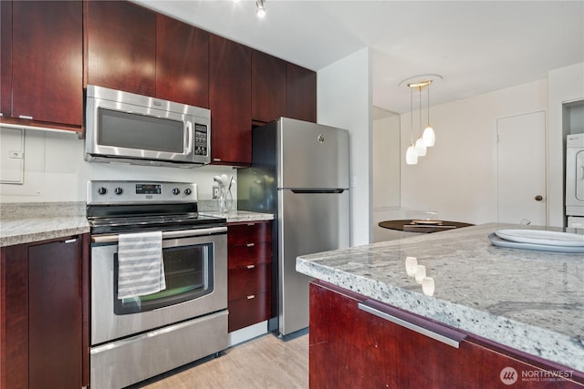 1400 Hubbell Pl Unit 909, Seattle, WA 98101 - kitchen with stainless steel appliances, dark brown cabinets, light wood-style floors, pendant lighting, and light stone countertops