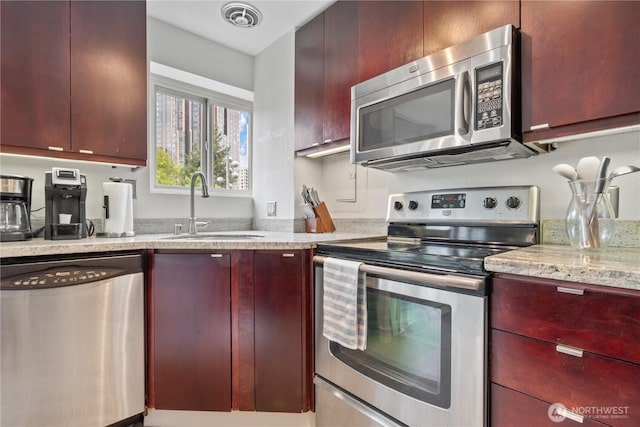 1400 Hubbell Pl Unit 909, Seattle, WA 98101 - kitchen with appliances with stainless steel finishes, dark brown cabinets, light stone counters, and modern cabinets