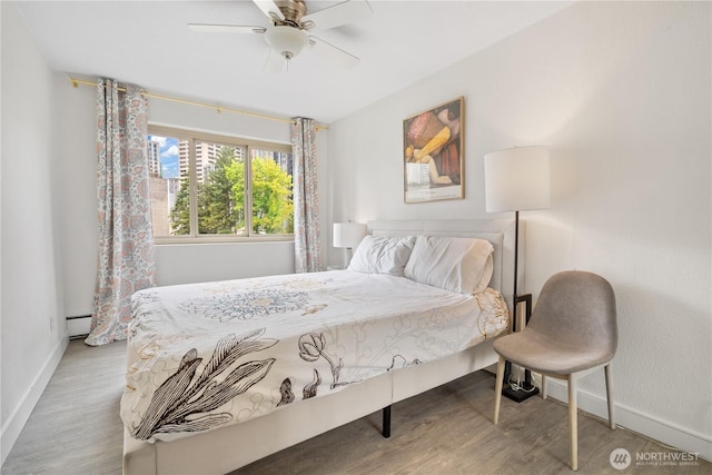 1400 Hubbell Pl Unit 909, Seattle, WA 98101 - bedroom featuring wood finished floors, a baseboard radiator, and ceiling fan