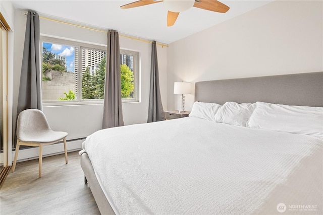 1400 Hubbell Pl Unit 909, Seattle, WA 98101 - bedroom featuring light wood-style floors, a ceiling fan, and a baseboard radiator
