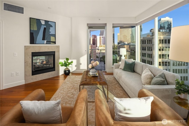 1920 4th Ave Unit 1105, Seattle, WA 98101 - living room featuring a view of city, wood finished floors, and a multi sided fireplace