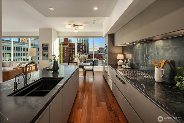 1920 4th Ave Unit 1105, Seattle, WA 98101 - kitchen with dark wood finished floors, modern cabinets, decorative backsplash, healthy amount of natural light, and recessed lighting