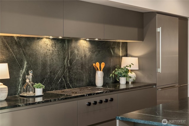 1920 4th Ave Unit 1105, Seattle, WA 98101 - detailed view of backsplash, modern cabinets, dark stone countertops, and cooktop
