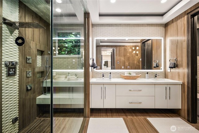 11210 SE 74th St, Newcastle, WA 98056 - bathroom featuring double vanity, a tile shower, wood finished floors, and recessed lighting