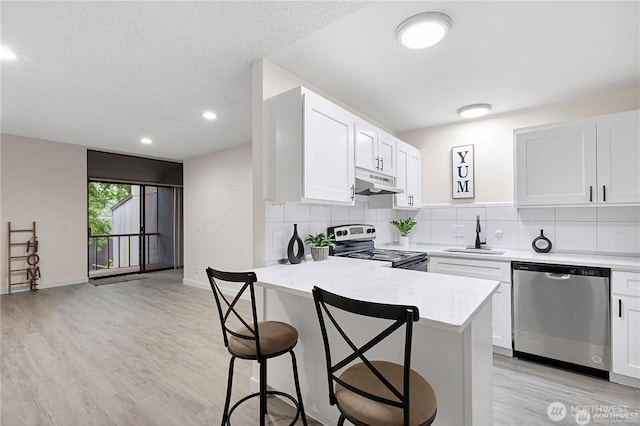 13838 NE 60th St Unit 165, Redmond, WA 98052 - kitchen with dishwasher, electric range, under cabinet range hood, a breakfast bar area, and tasteful backsplash