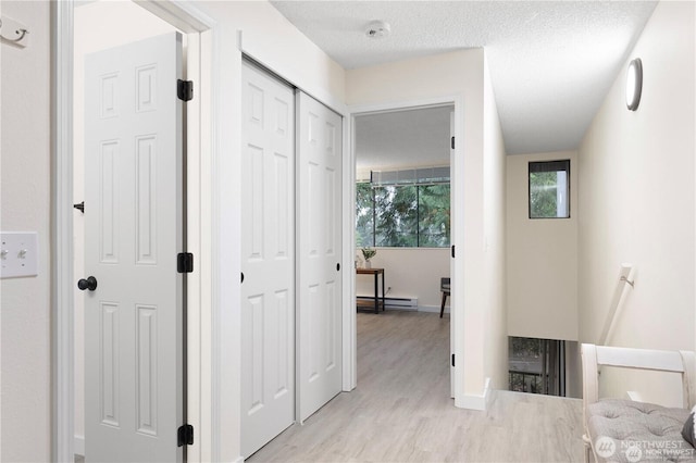 13838 NE 60th St Unit 165, Redmond, WA 98052 - hall featuring an upstairs landing, a baseboard heating unit, and light wood-type flooring