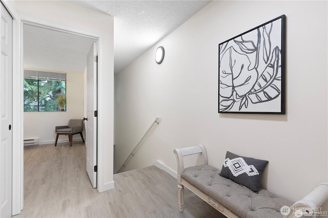 13838 NE 60th St Unit 165, Redmond, WA 98052 - corridor with an upstairs landing, a baseboard heating unit, and light wood-style flooring