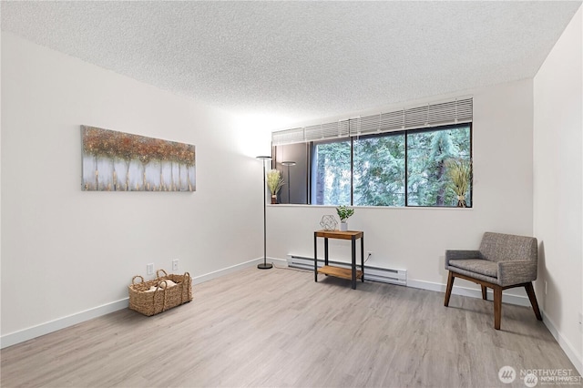 13838 NE 60th St Unit 165, Redmond, WA 98052 - living area featuring a baseboard heating unit, wood finished floors, and a textured ceiling