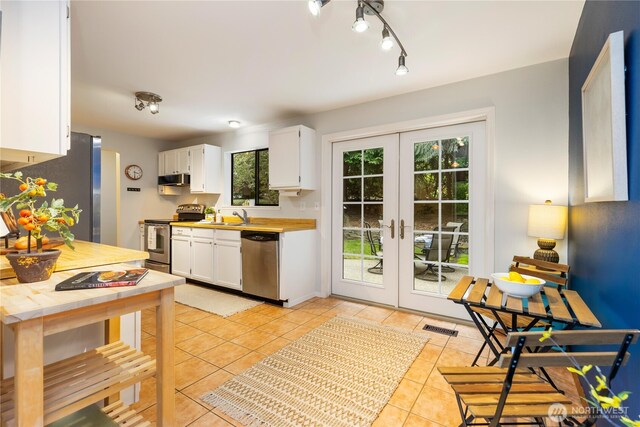 26639 NE Stewart St, Duvall, WA 98019 - kitchen with stainless steel appliances, white cabinetry, light tile patterned flooring, and french doors