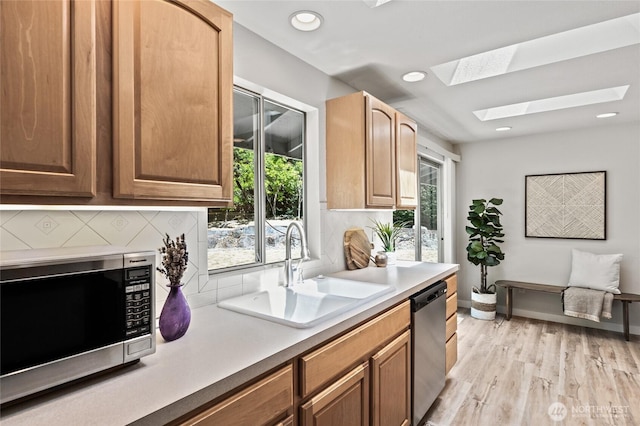 13726 SE 24th St, Bellevue, WA 98005 - kitchen with stainless steel appliances, a skylight, plenty of natural light, light countertops, and recessed lighting
