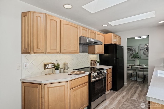 13726 SE 24th St, Bellevue, WA 98005 - kitchen featuring stainless steel electric stove, under cabinet range hood, light brown cabinets, a skylight, and freestanding refrigerator