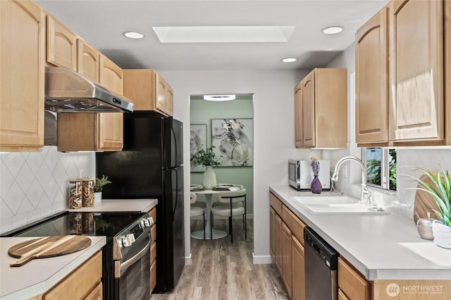 13726 SE 24th St, Bellevue, WA 98005 - kitchen with appliances with stainless steel finishes, under cabinet range hood, a skylight, light brown cabinets, and light wood-type flooring