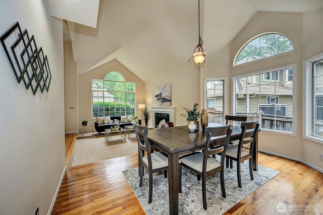 5044 157th Ct NE, Redmond, WA 98052 - dining room with light wood-style floors, high vaulted ceiling, and a fireplace