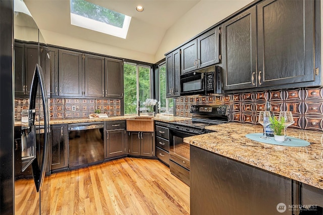 5044 157th Ct NE, Redmond, WA 98052 - kitchen featuring black appliances, a skylight, lofted ceiling, decorative backsplash, and light wood-style flooring