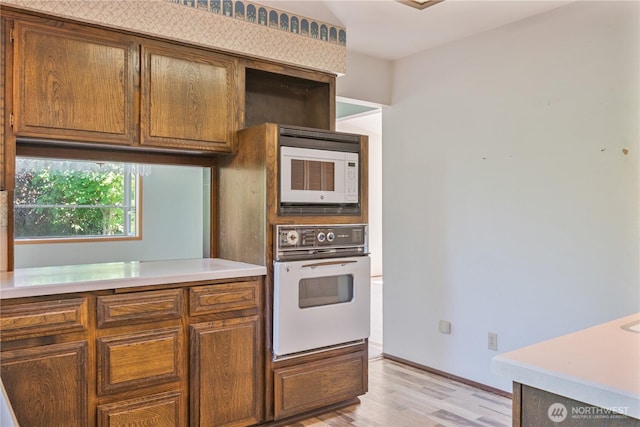 17 Jeffery Pl, Longview, WA 98632 - kitchen featuring white appliances, light wood finished floors, light countertops, and brown cabinets