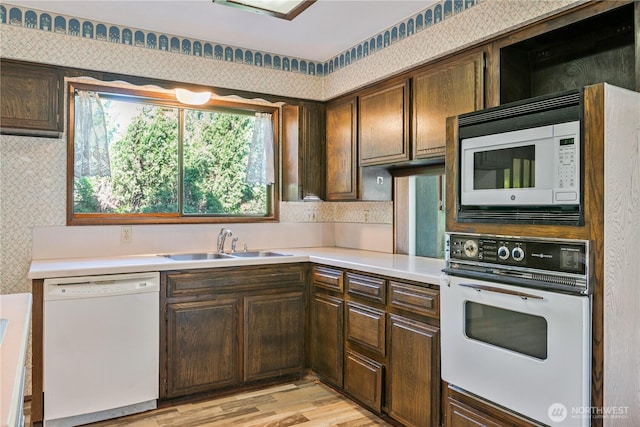 17 Jeffery Pl, Longview, WA 98632 - kitchen with white appliances, wallpapered walls, light countertops, light wood-style flooring, and dark brown cabinets
