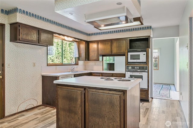 17 Jeffery Pl, Longview, WA 98632 - kitchen featuring white appliances, wallpapered walls, light wood-style flooring, light countertops, and a center island