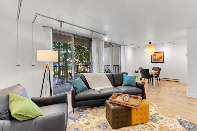 4540 8th Ave NE Unit 202, Seattle, WA 98105 - living area featuring track lighting, wood finished floors, baseboard heating, and a textured ceiling
