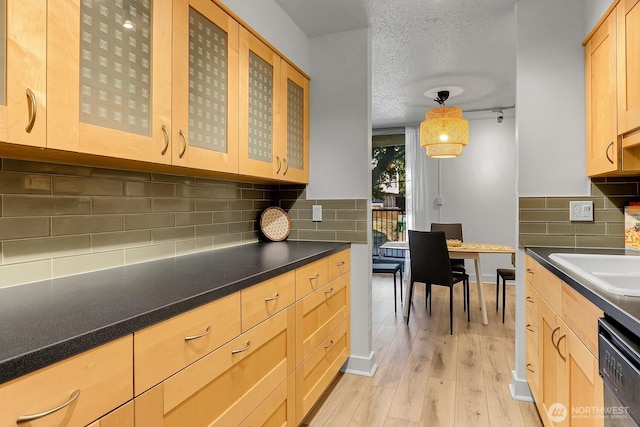 4540 8th Ave NE Unit 202, Seattle, WA 98105 - kitchen featuring dishwasher, light wood finished floors, light brown cabinetry, dark countertops, and glass insert cabinets