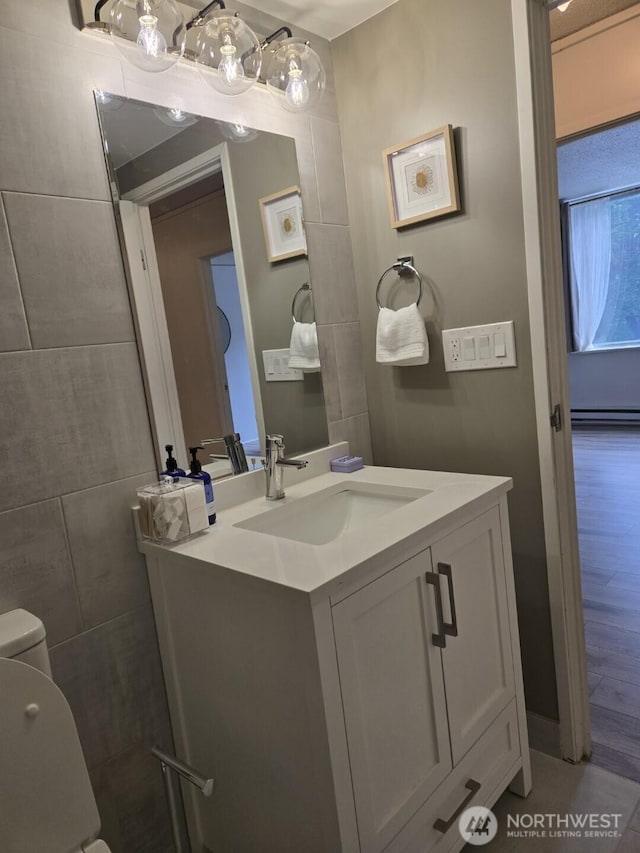 4540 8th Ave NE Unit 202, Seattle, WA 98105 - half bath featuring vanity, wood finished floors, and baseboard heating