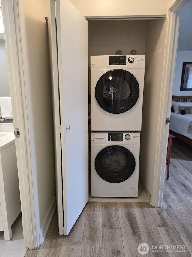 4540 8th Ave NE Unit 202, Seattle, WA 98105 - laundry area featuring stacked washer / drying machine and wood finished floors