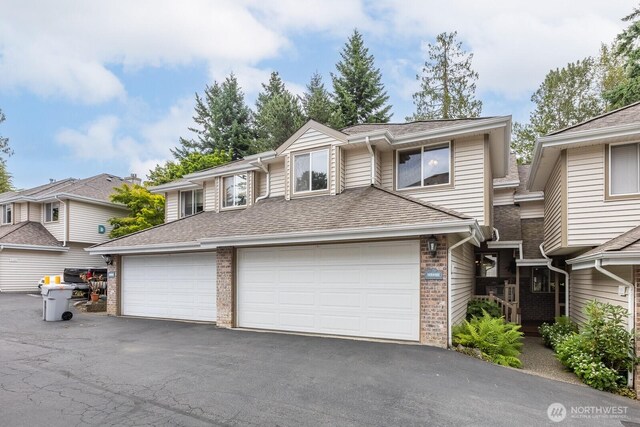 23430 100th Ave SE Unit E102, Kent, WA 98031 - townhome / multi-family property featuring brick siding, driveway, roof with shingles, and a garage