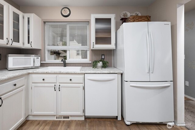 23430 100th Ave SE Unit E102, Kent, WA 98031 - kitchen featuring white appliances, white cabinetry, light countertops, and glass insert cabinets