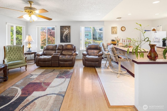 3235 33rd Ave S, Seattle, WA 98144 - living room featuring wood finished floors, a textured ceiling, a ceiling fan, and recessed lighting