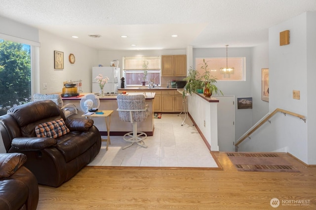 3235 33rd Ave S, Seattle, WA 98144 - living room featuring a chandelier, recessed lighting, light wood-style floors, and a textured ceiling