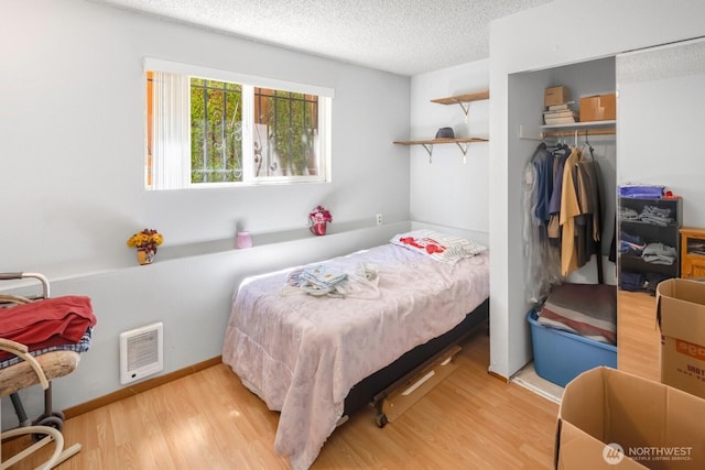 3235 33rd Ave S, Seattle, WA 98144 - bedroom featuring wood finished floors, a closet, a textured ceiling, and heating unit
