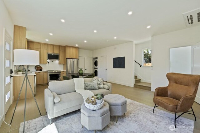 12046 5th Ave NE, Seattle, WA 98125 - living room with estacked washer and dryer, stairway, light wood-style floors, and recessed lighting