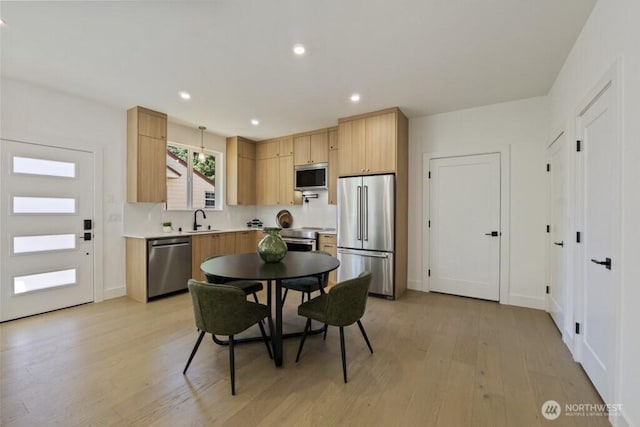 12046 5th Ave NE, Seattle, WA 98125 - kitchen with appliances with stainless steel finishes, light wood-style flooring, light brown cabinetry, light countertops, and recessed lighting