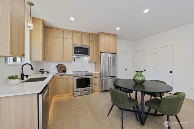 12046 5th Ave NE, Seattle, WA 98125 - kitchen with appliances with stainless steel finishes, light brown cabinetry, light countertops, light wood-type flooring, and tasteful backsplash