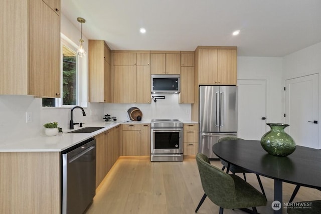 12046 5th Ave NE, Seattle, WA 98125 - kitchen with appliances with stainless steel finishes, light brown cabinetry, light countertops, light wood-style floors, and pendant lighting
